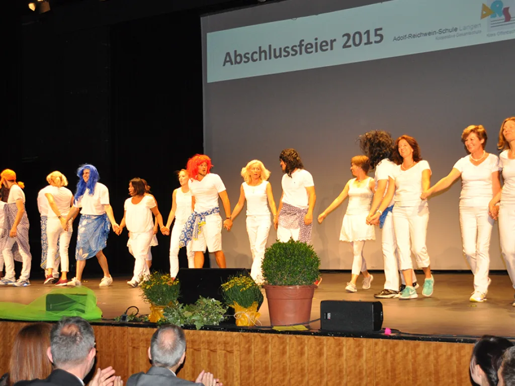 Die Tanzgruppe in Weiß bewegt sich über die Bühne.